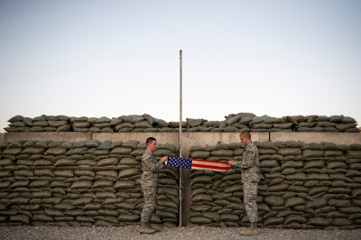Two airmen fold a flag during the retreat call at Camp Etchberger in what was once "The Quiet Place."