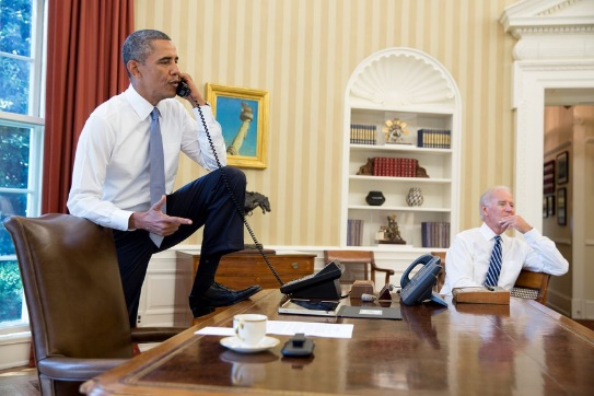 Obama puts his foot on the desk.