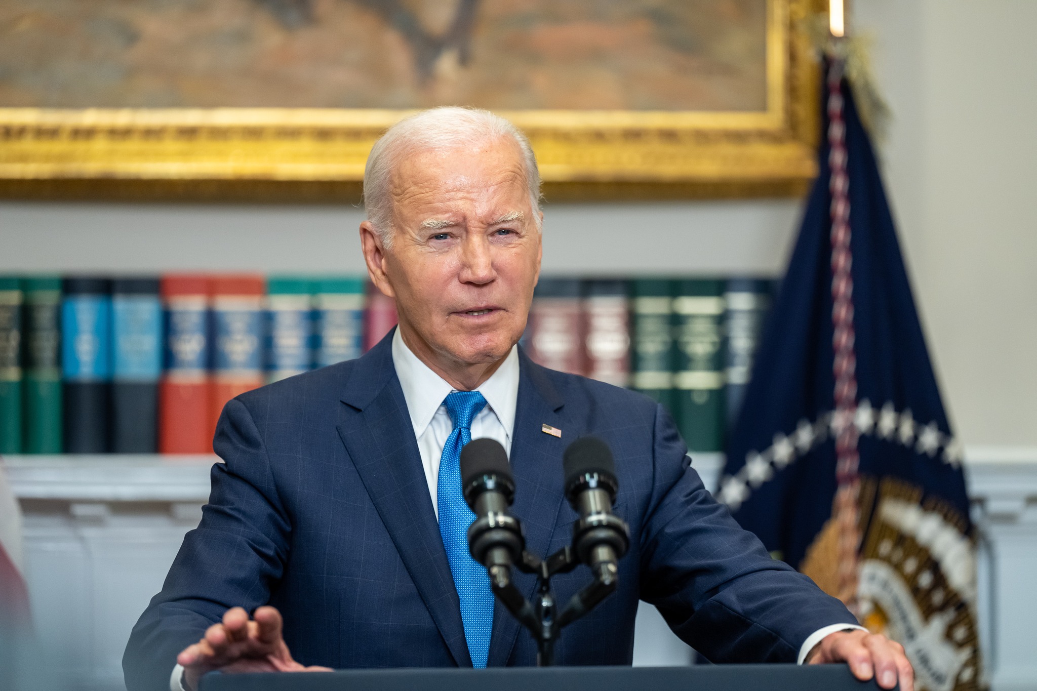 Biden with books in background in the Roosevelt Room
