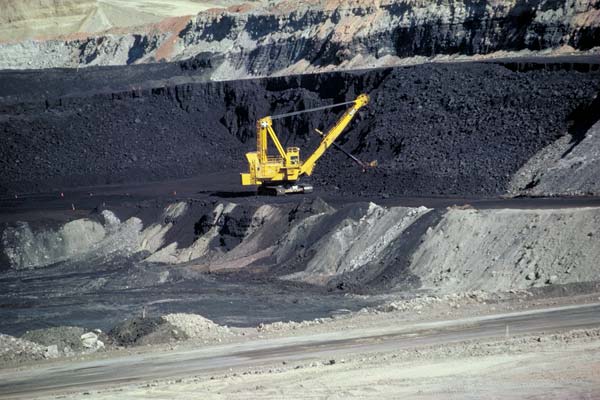 Coal mining in action - a shovel digs coal from a stratum