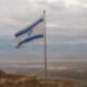 Flag of Israel before a cloudy sky