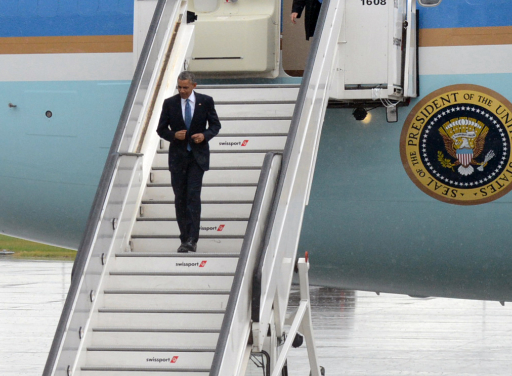 Obama crooks his arms as he skips down the boarding stairs from Air Force One