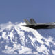 F-35A passing a snow-covered mountain