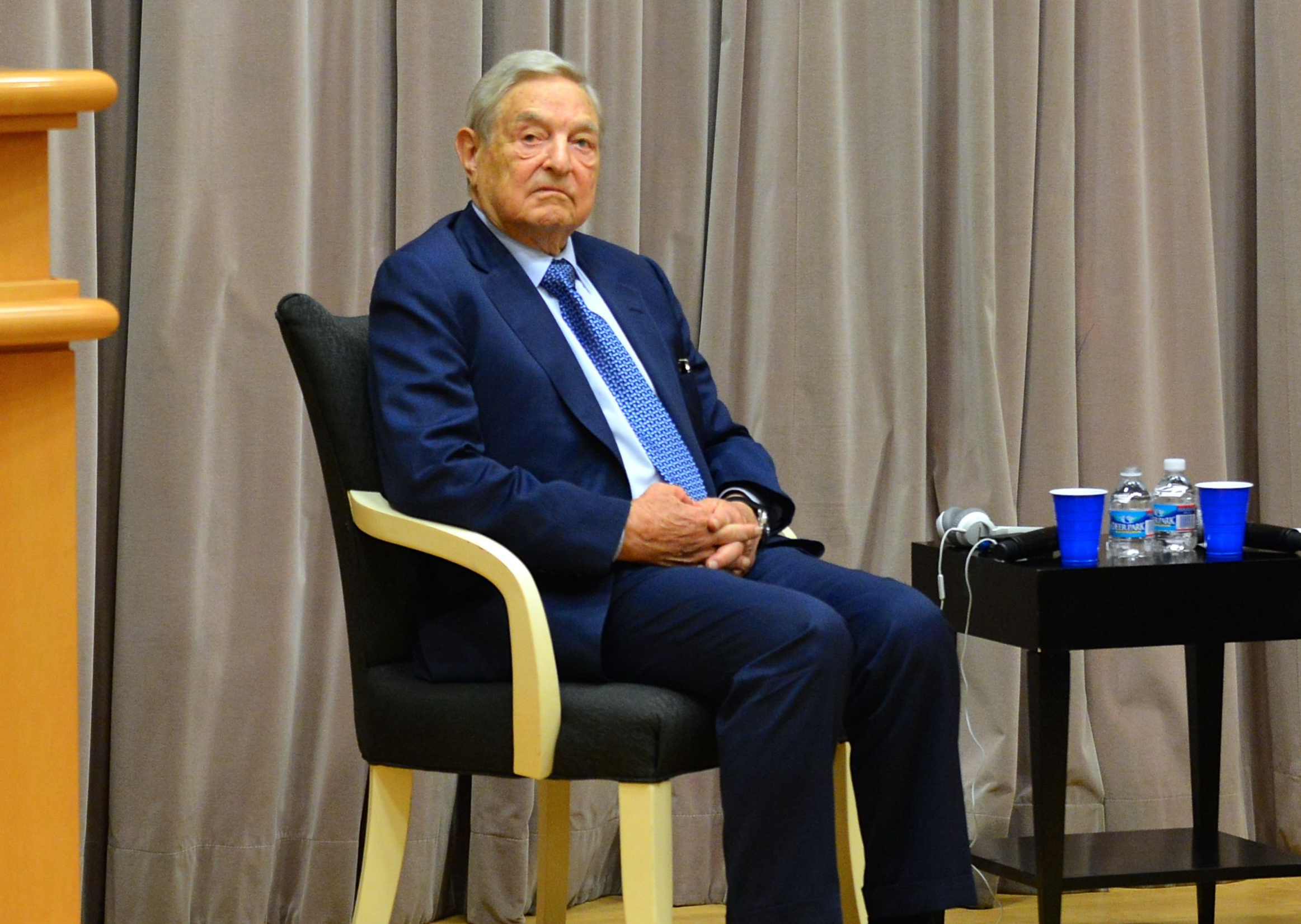 George Soros with two water bottles on a table