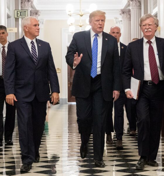 President Donald Trump, with Vice-President Mike Pence and former NSA John Bolton flanking him, with three other men walking behind.
