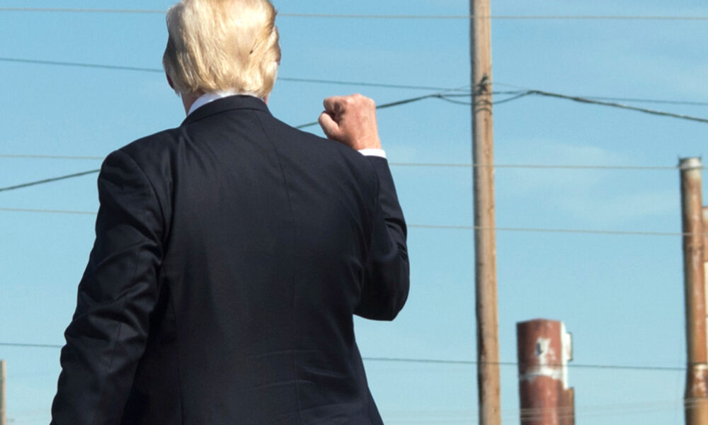 Donald Trump from back facing utility poles and wires