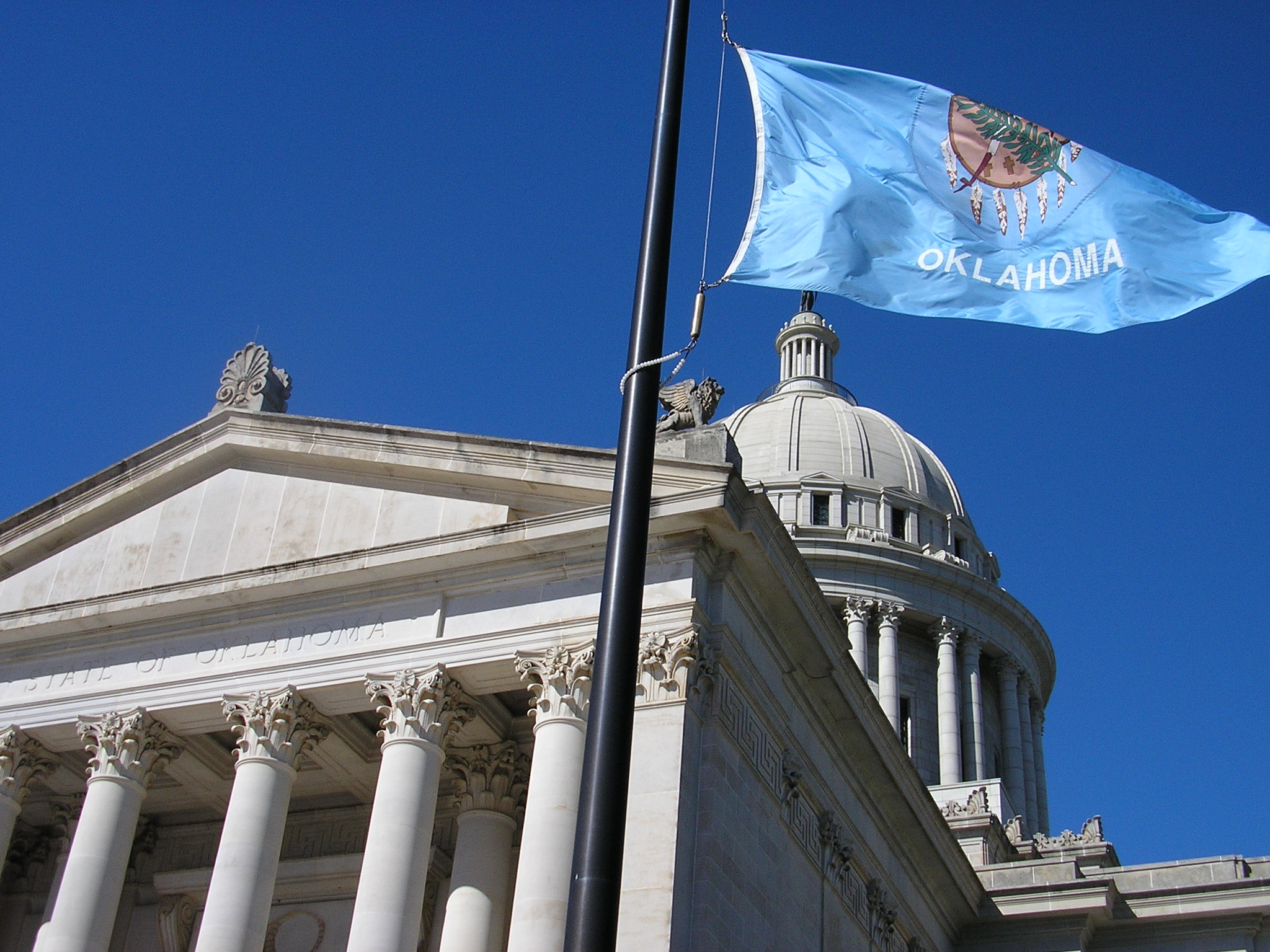 Flag of Oklahoma next to Oklahoma State capitol