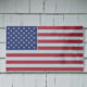 Flag of USA tacked onto outside house wall made of shingles