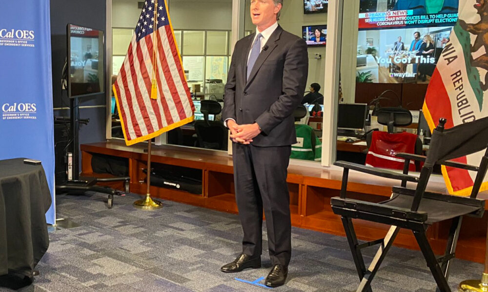 Gavin Newsom within, or in front of, a glass-in office