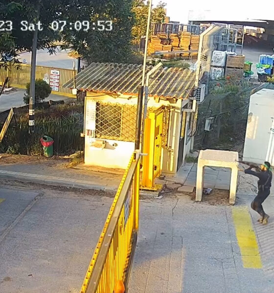 HAMAS operative (foreground, at right) shoots through the gate at a kibbutz in the Negev on 7 October 2023.