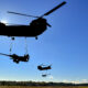 Two CH-47 Chinook helicopters lift heavy artillery pieces during training at Fort Stewart, Georgia