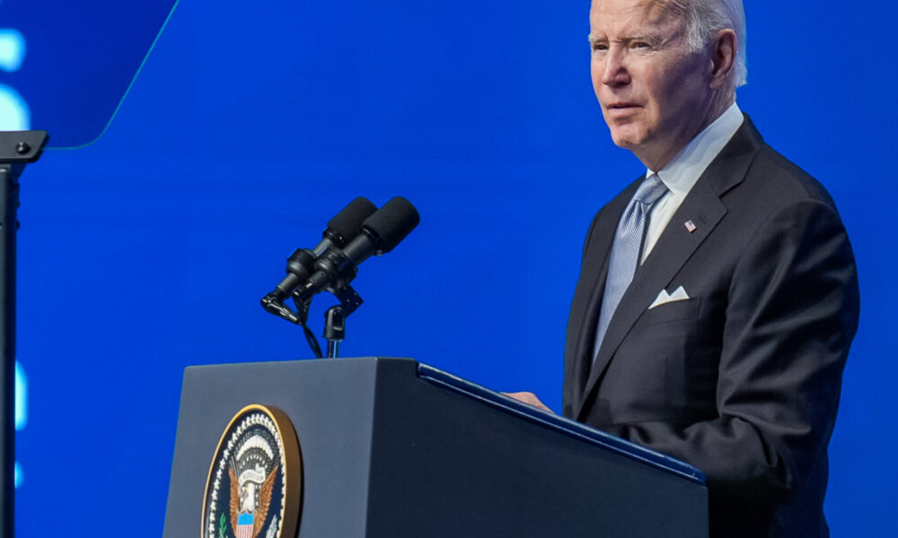 Biden in left profile at podium blue background