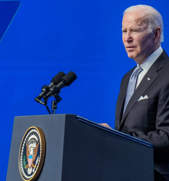Biden in left profile at podium blue background