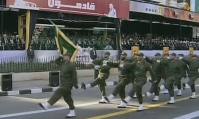 Hezbollah regulars parade down a city street