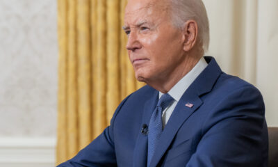 Joe Biden in left front angle with gold curtain in background