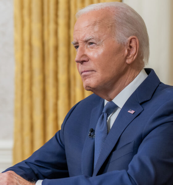 Joe Biden in left front angle with gold curtain in background