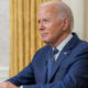 Joe Biden in left front angle with gold curtain in background