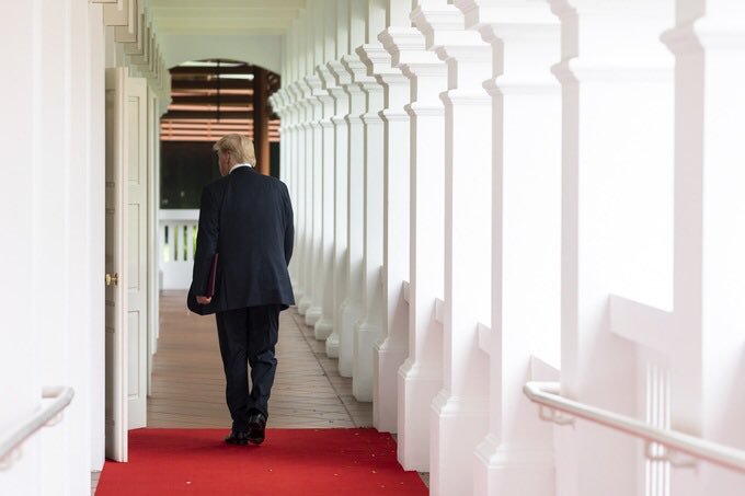 Donald Trup walks past a colonnade
