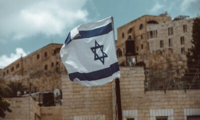 Israel flag flying near brick walls in an Israeli city (Jerusalem? Akko?)