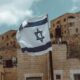 Israel flag flying near brick walls in an Israeli city (Jerusalem? Akko?)