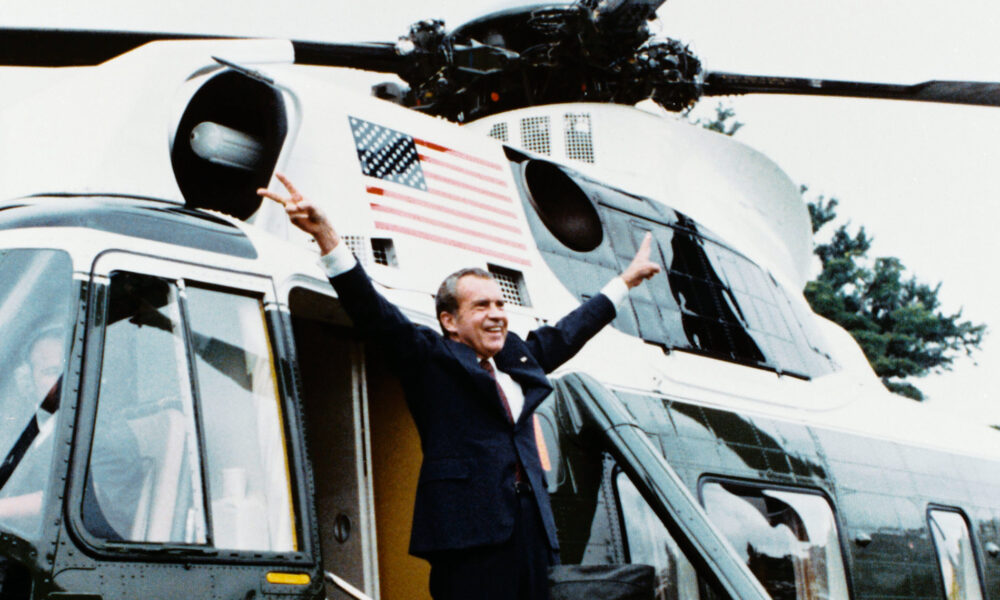 President Richard M. Nixon flashes his double victory sign before boarding Marine One for the last time.