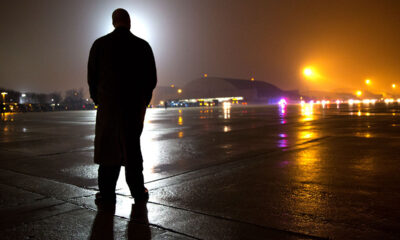 A Secret Service agent waits on the tarmac of an air base (probably Joint Base Andrews)