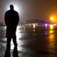 A Secret Service agent waits on the tarmac of an air base (probably Joint Base Andrews)