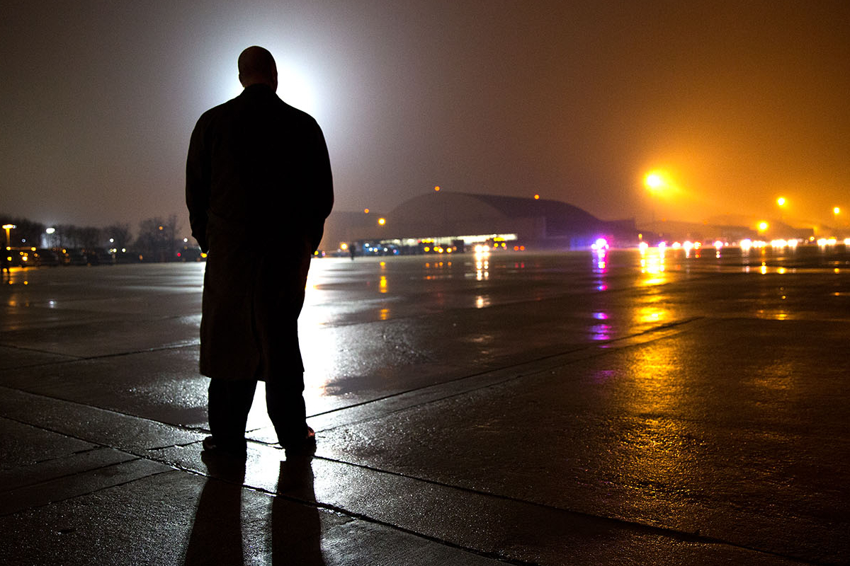 A Secret Service agent waits on the tarmac of an air base (probably Joint Base Andrews)