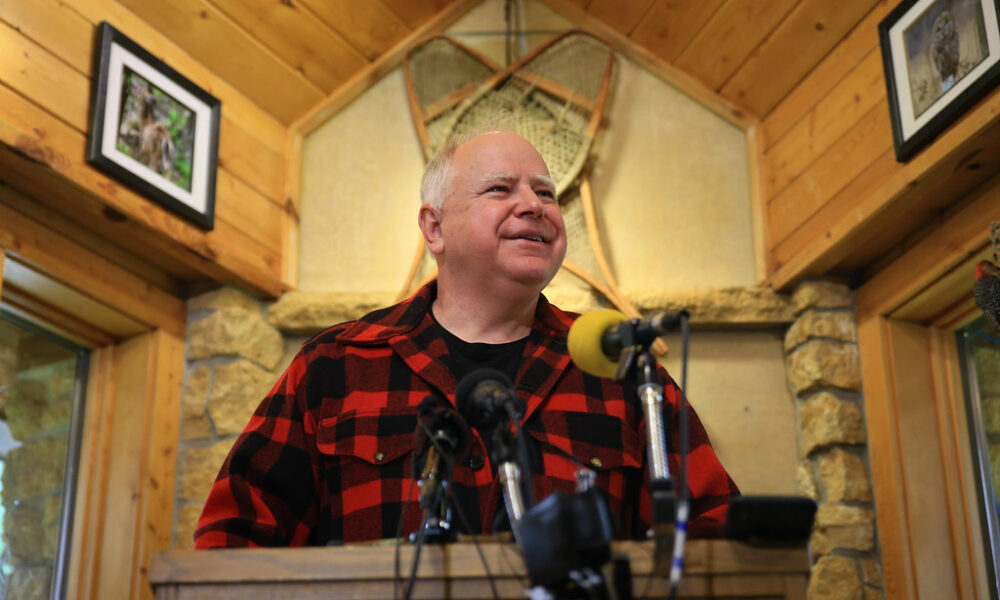 Tim Walz speaks inside a hunting lodge