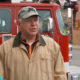 Governor Tim Walz of Minnesota next to a fire pumper with a Wells Fargo Bank branch in background