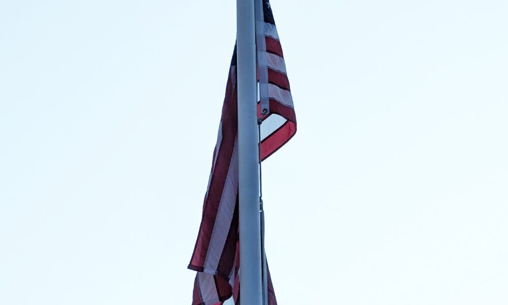 American flag hanging limp on poll in Arlington, Massachusetts