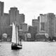 Boston skyline looking in from Boston Harbor, with wooden museum sailing vessel (USS Constitution?) in foreground