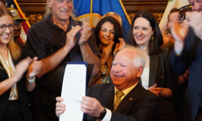 Tim Walz conducting a bill signing with several onlookers