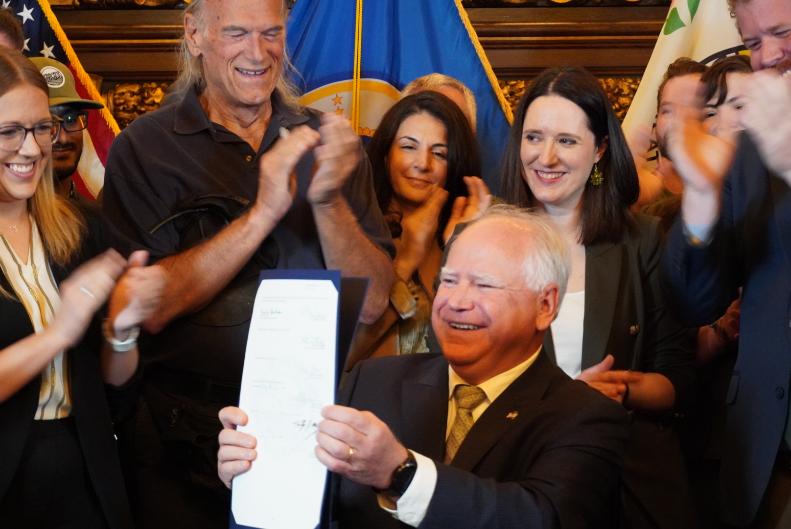 Tim Walz conducting a bill signing with several onlookers