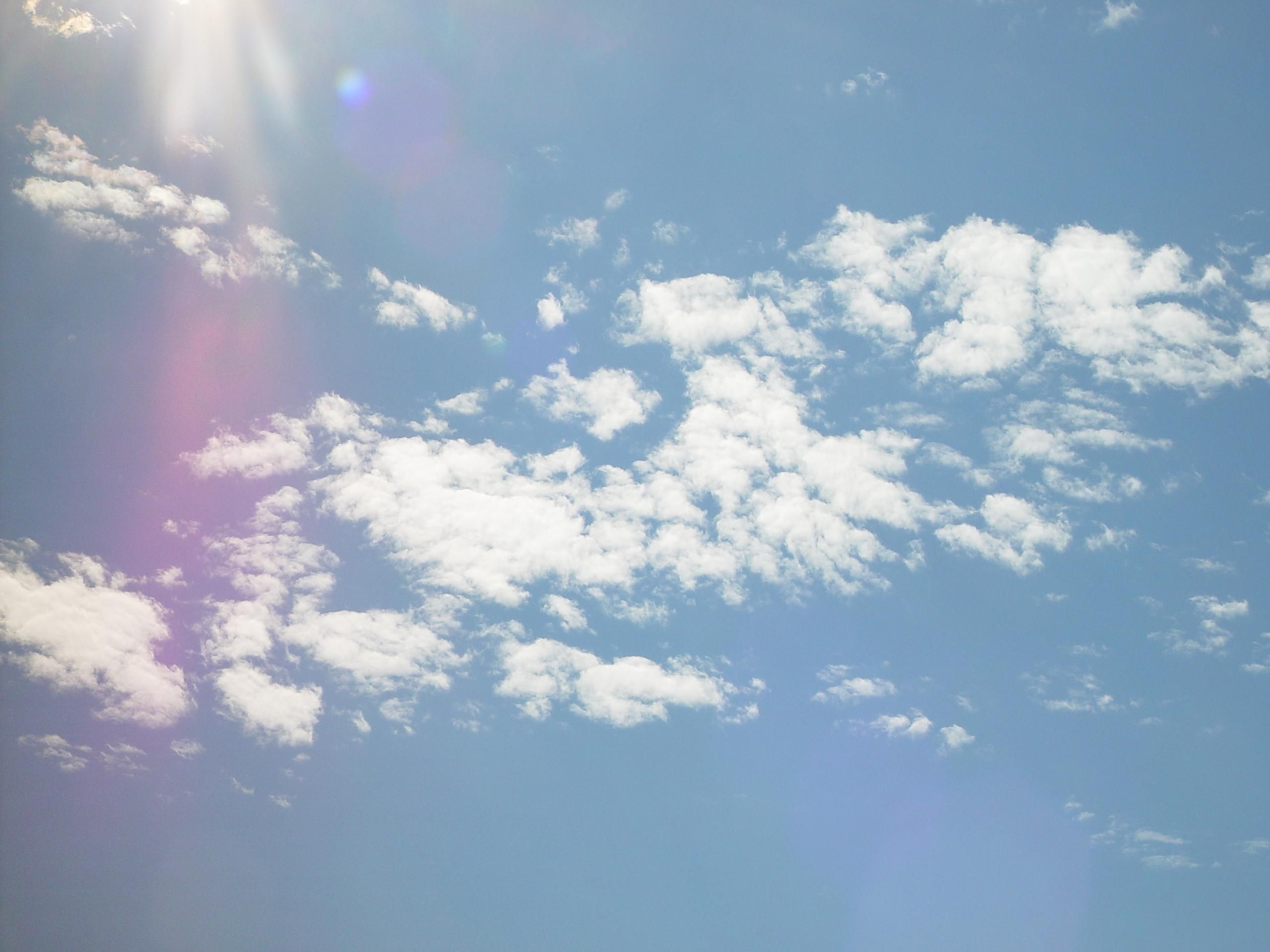 Cirrocumulus clouds with the sun creating a lens flare