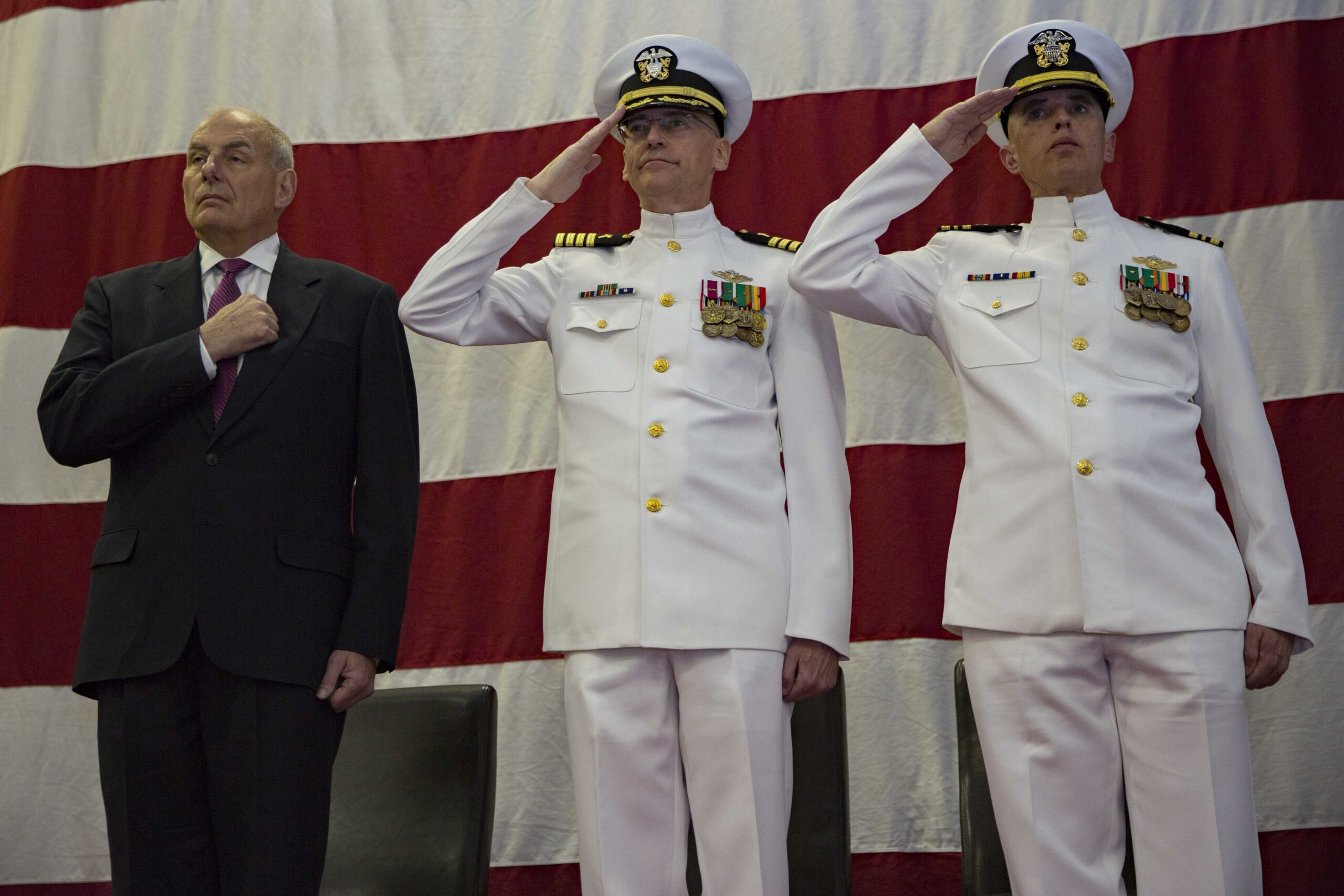 US SecHomeSec John Kelly, Captain William Huhm USN, and Lt Cmdr Charles Johnson USN aboard USS Kearsage LHD 3 at a change of command