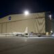 A NASA long-winged plane next to a hangar at the Palmdale Facility.