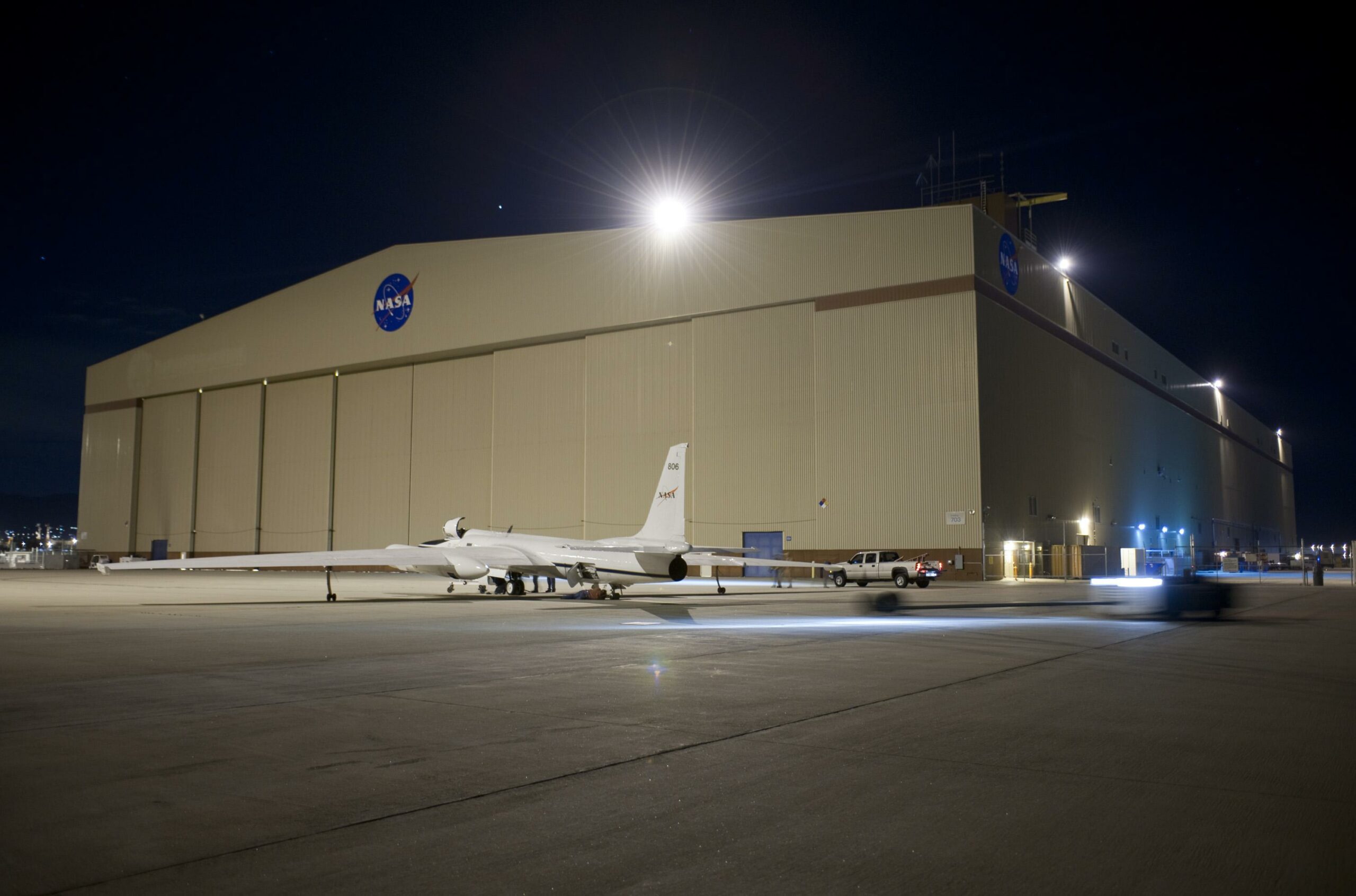 A NASA long-winged plane next to a hangar at the Palmdale Facility.