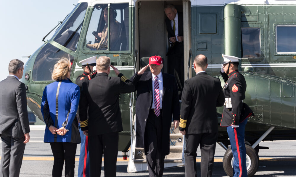 Donald Trump disembarks from Marine One and takes several salutes.