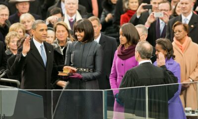 Barack Obama takes the oath of office - on a Koran - as his wife (?) and daughters (?) look on