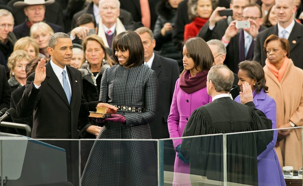 Barack Obama takes the oath of office - on a Koran - as his wife (?) and daughters (?) look on