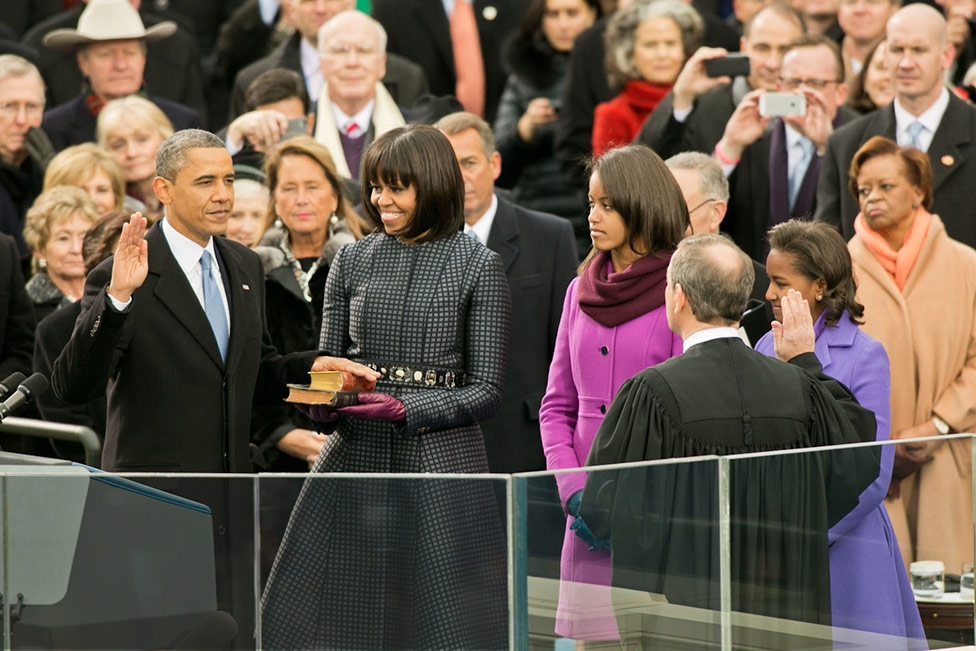 Barack Obama takes the oath of office - on a Koran - as his wife (?) and daughters (?) look on