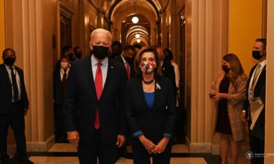 Joe Biden and Nancy Pelosi walk down a corridor - and everyone is masked up in fear of the dreaded coronavirus, putative cause of COVID