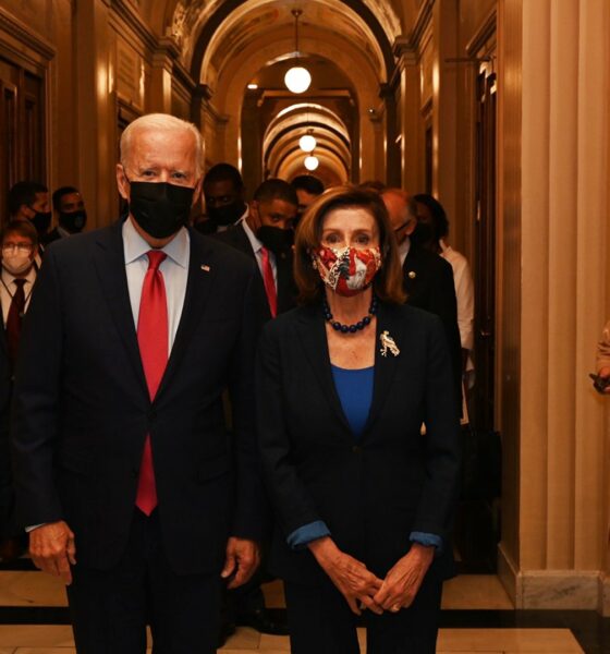 Joe Biden and Nancy Pelosi walk down a corridor - and everyone is masked up in fear of the dreaded coronavirus, putative cause of COVID