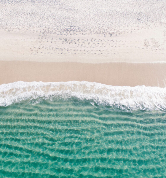 Ocean waves lapping on a beach, where most coastal communities employ lifeguards