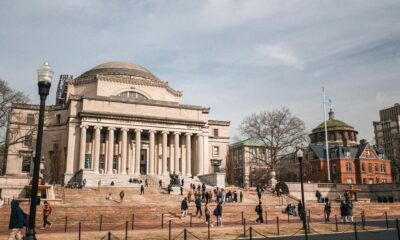 Columbia University library, oblique front-right elevation, with students congregating in small groups on the steps.