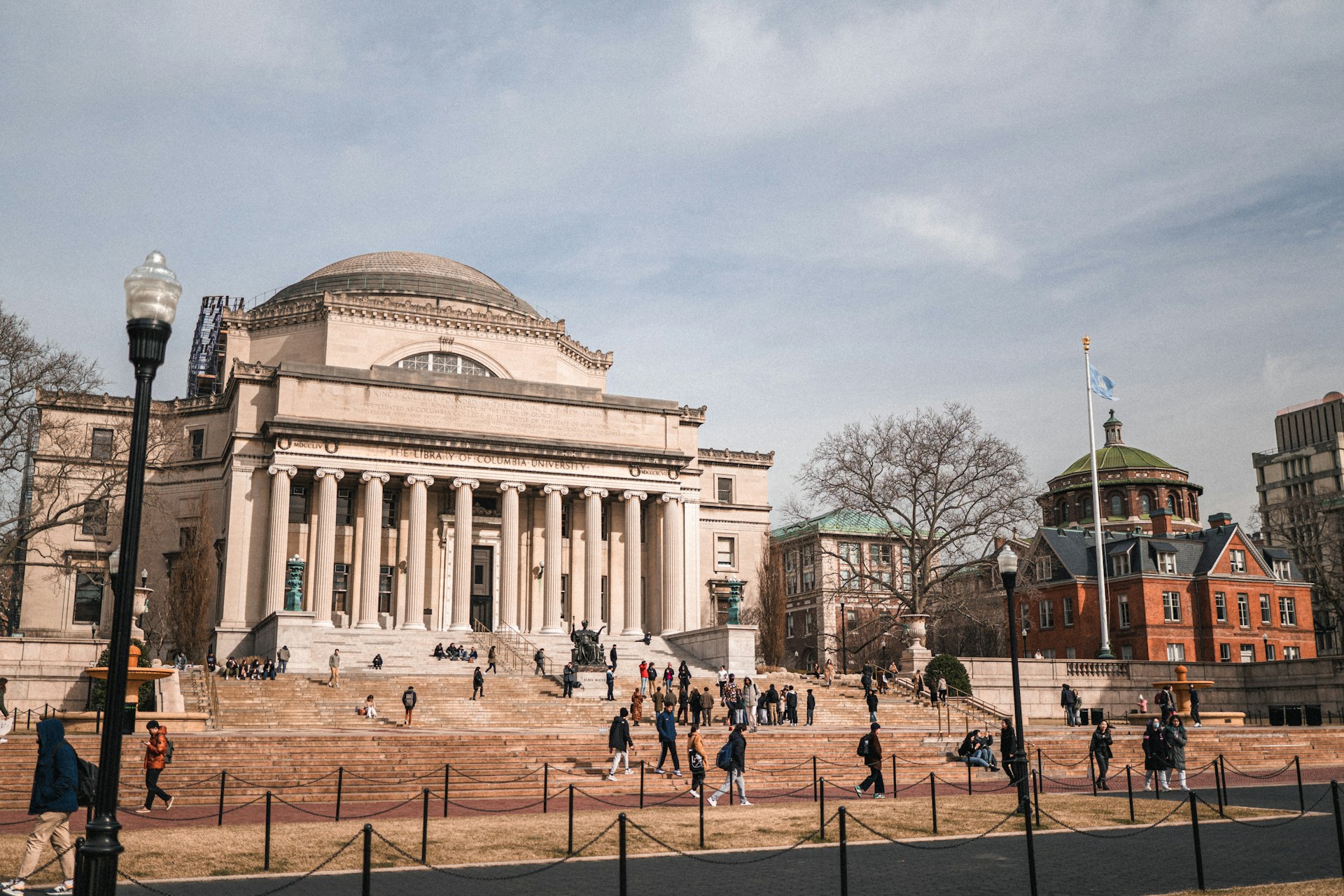 Columbia University library, oblique front-right elevation, with students congregating in small groups on the steps.