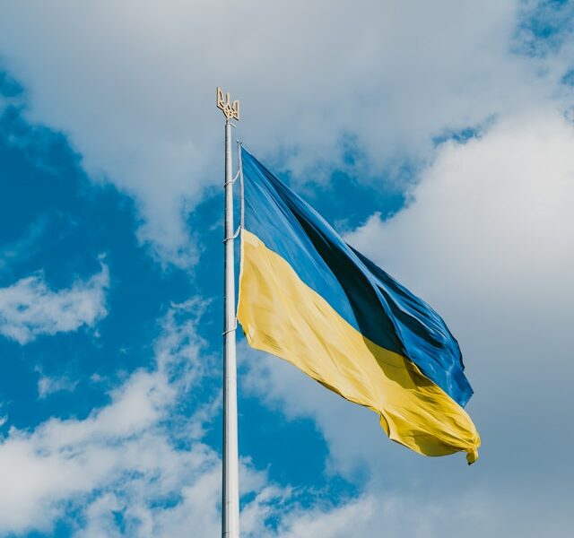 Flag of Ukraine on a flagpole with the Ukrainian raven on top