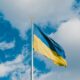 Flag of Ukraine on a flagpole with the Ukrainian raven on top