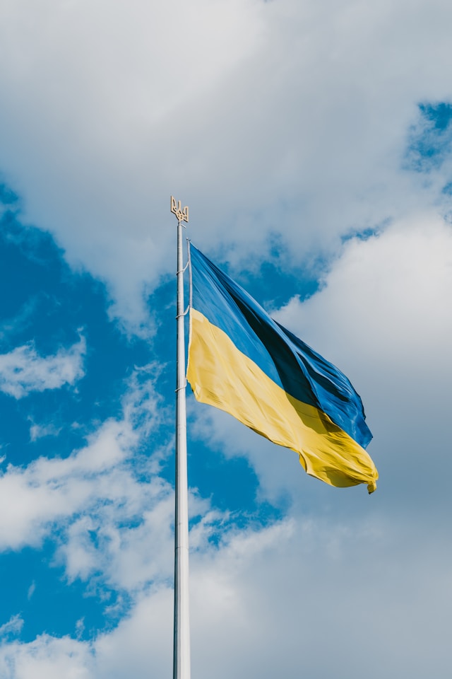 Flag of Ukraine on a flagpole with the Ukrainian raven on top